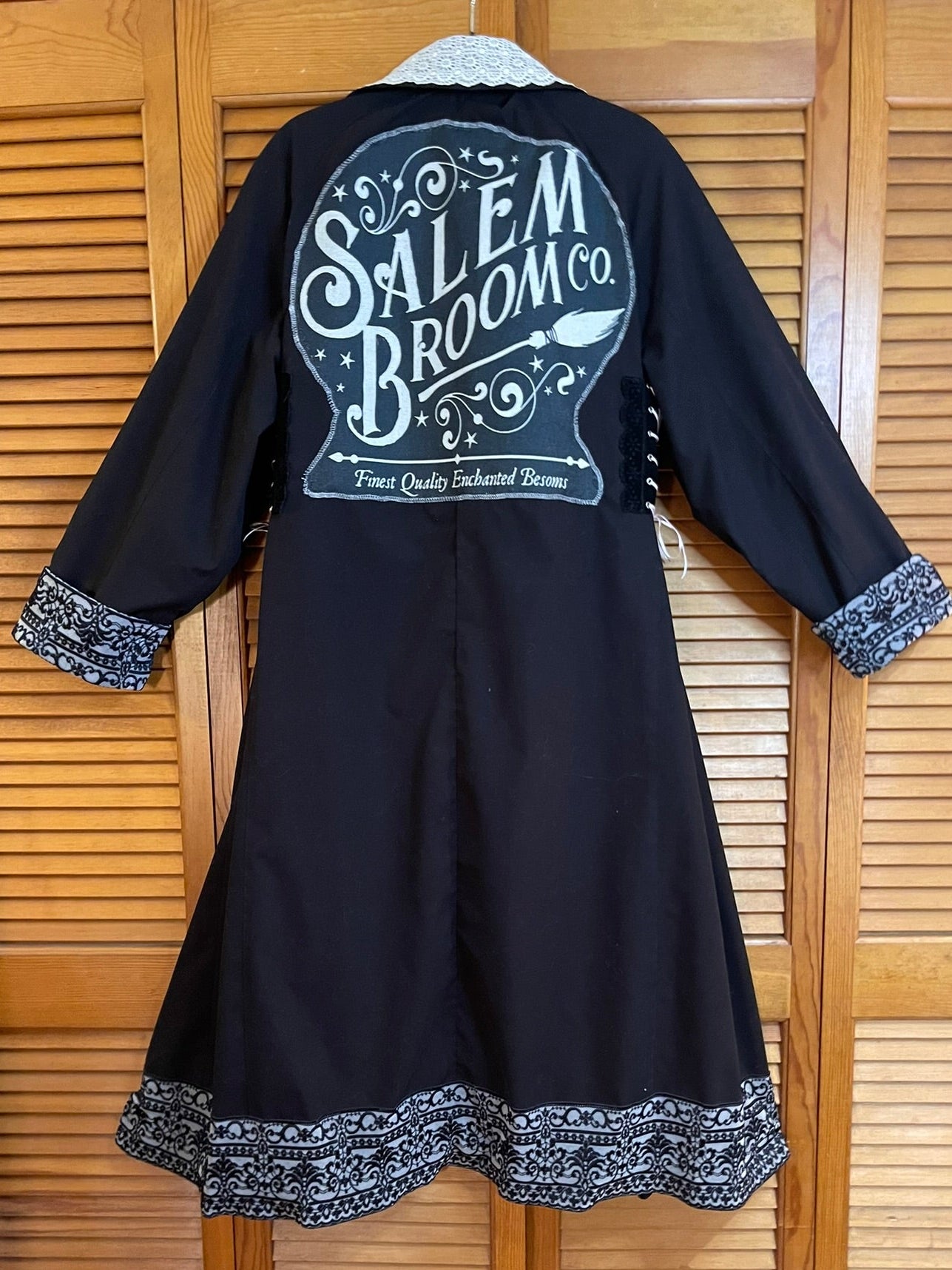 Black dress with white lace trim on a wooden background